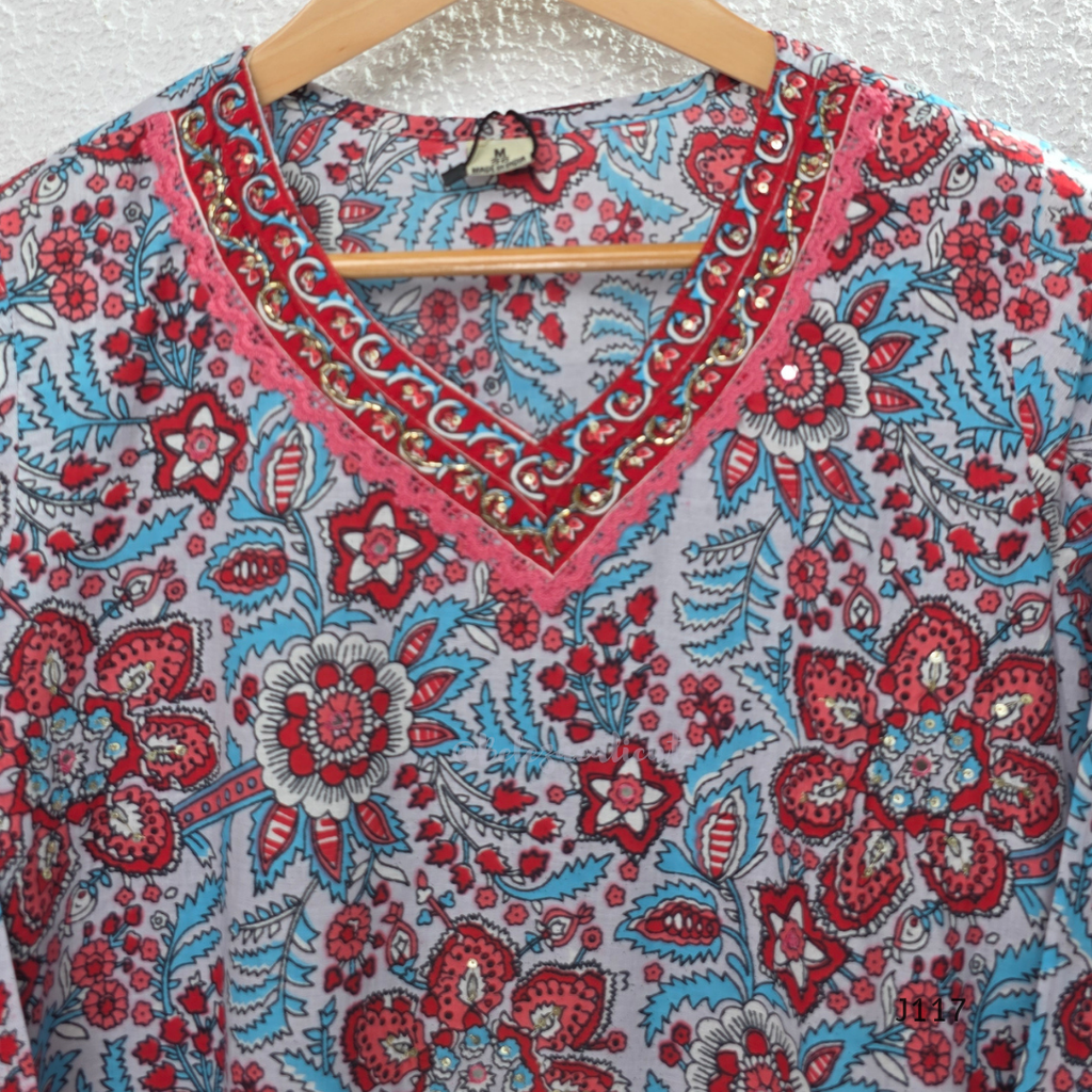 White ivory cotton 3-piece churidar set with dense red and blue kalamkari-style block print, gold sequin V-neckline, lace cuff, and printed dupatta with bold red border.