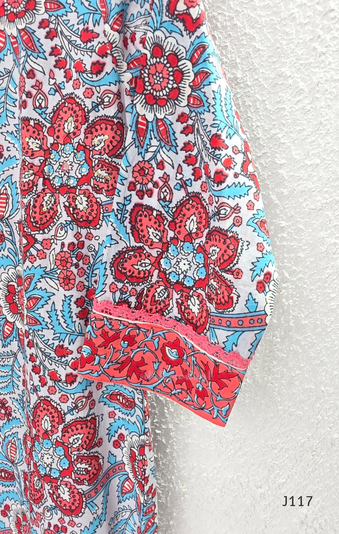 White ivory cotton 3-piece churidar set with dense red and blue kalamkari-style block print, gold sequin V-neckline, lace cuff, and printed dupatta with bold red border.