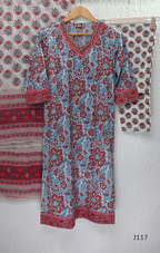 White ivory cotton 3-piece churidar set with dense red and blue kalamkari-style block print, gold sequin V-neckline, lace cuff, and printed dupatta with bold red border.