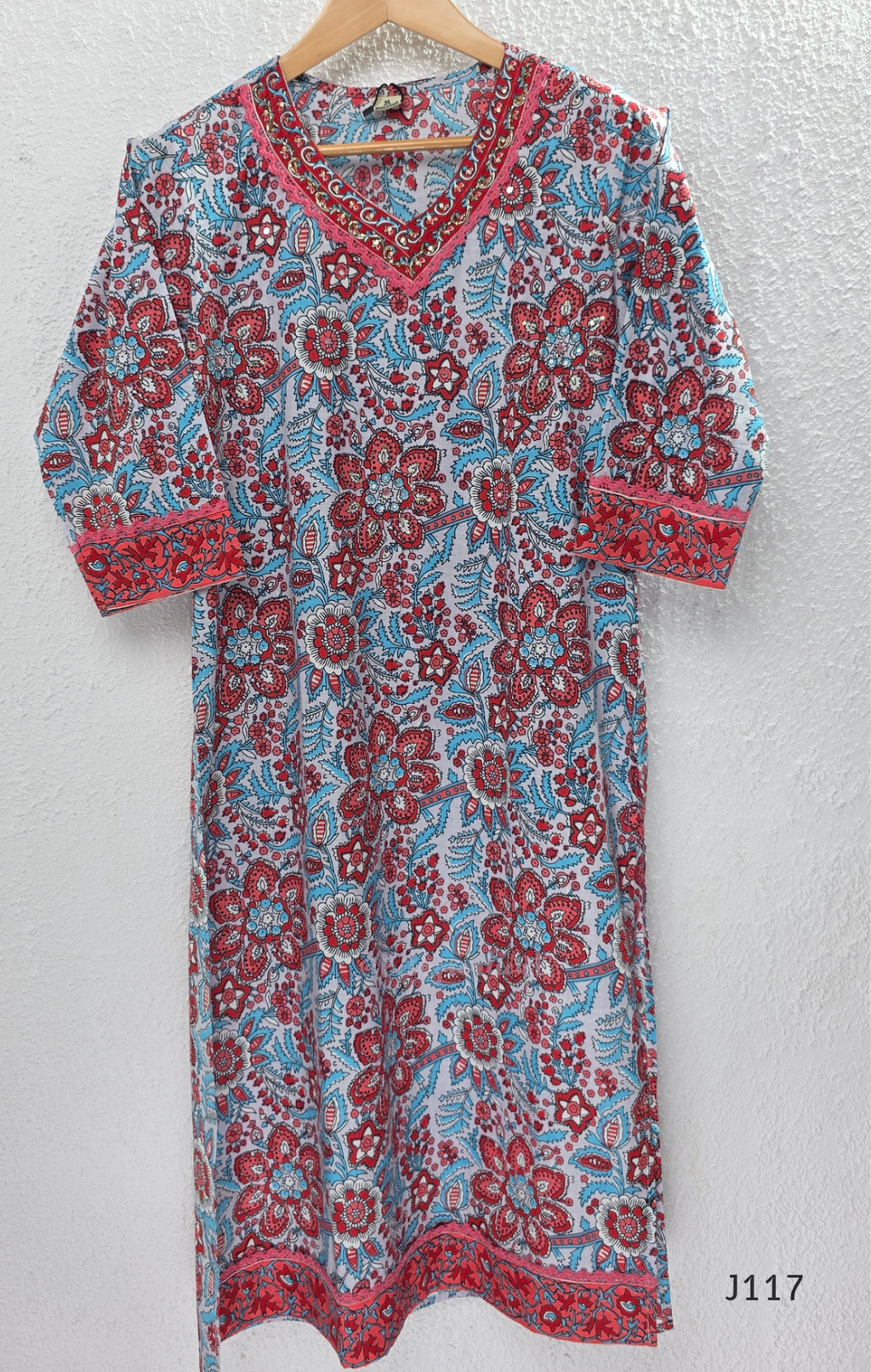 White ivory cotton 3-piece churidar set with dense red and blue kalamkari-style block print, gold sequin V-neckline, lace cuff, and printed dupatta with bold red border.