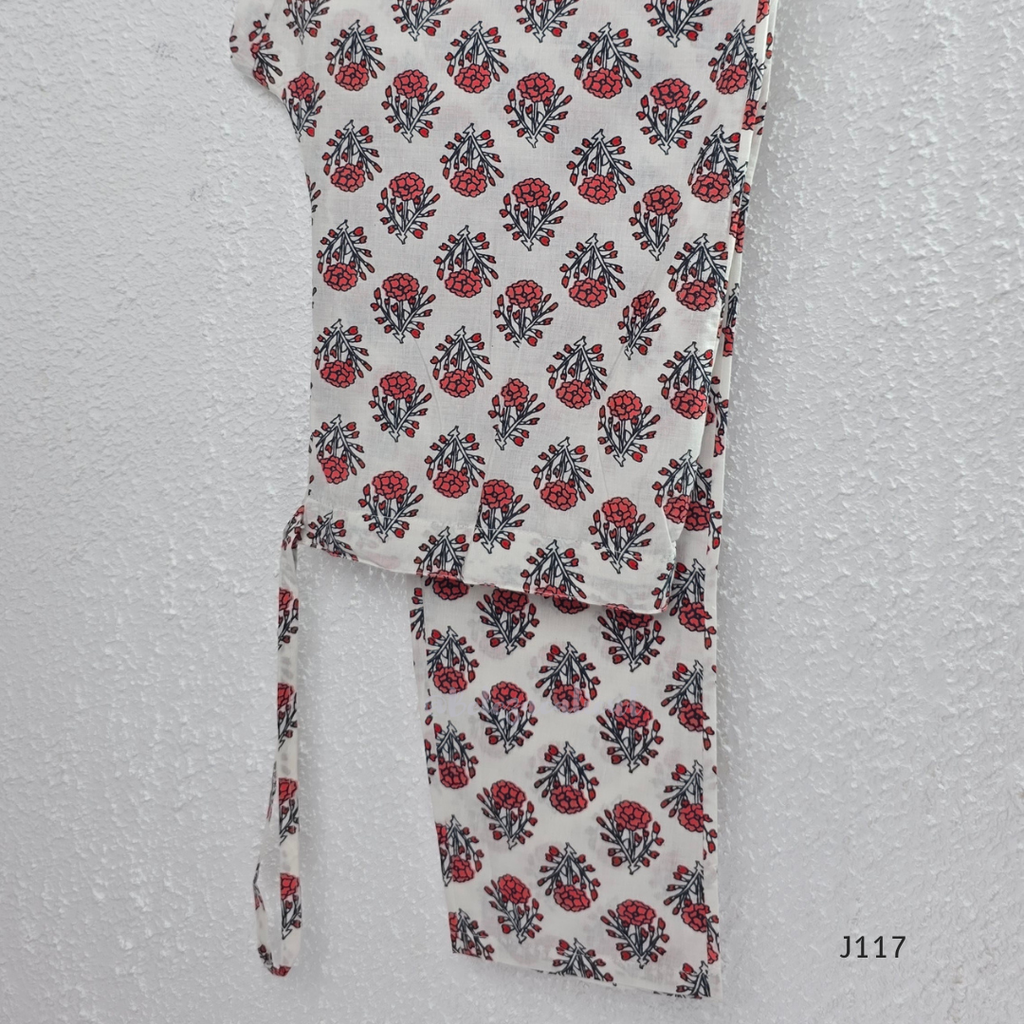 White ivory cotton 3-piece churidar set with dense red and blue kalamkari-style block print, gold sequin V-neckline, lace cuff, and printed dupatta with bold red border.