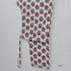 White ivory cotton 3-piece churidar set with dense red and blue kalamkari-style block print, gold sequin V-neckline, lace cuff, and printed dupatta with bold red border.