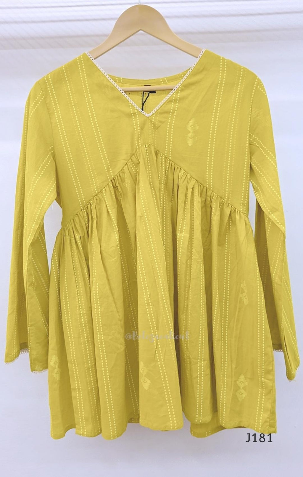 Yellow-green cotton short top with vertical dotted design, gathered flared yoke and bell sleeves.