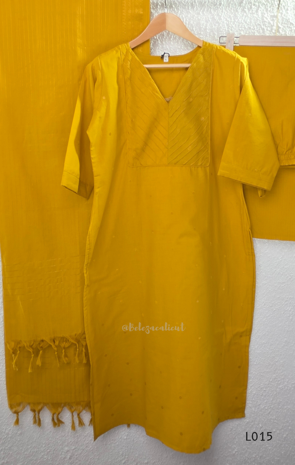 Yellow cotton lined 3-piece ethnic set with V-neck pintuck yoke, matching straight pant and textured tassel dupatta.