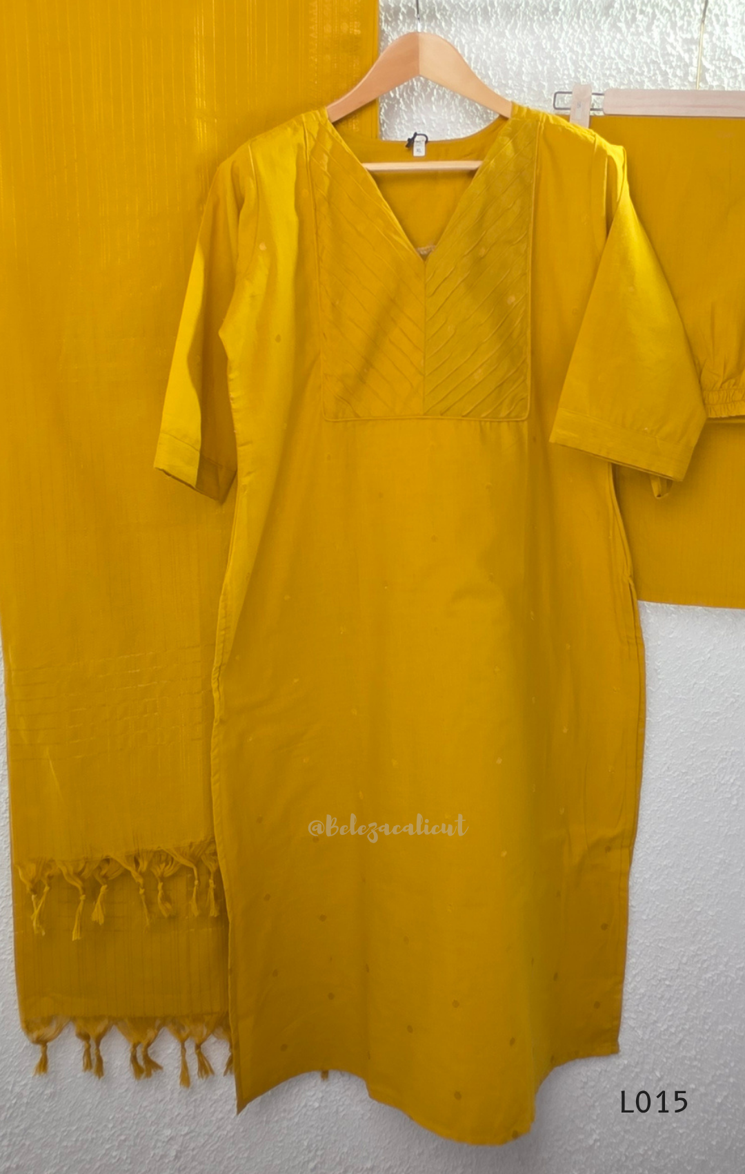 Yellow cotton lined 3-piece ethnic set with V-neck pintuck yoke, matching straight pant and textured tassel dupatta.