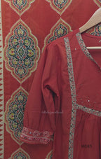 Rust-orange cotton churidar set with decorative patchwork-style trims, gathered yoke, straight pants and printed dupatta.