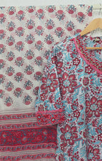 White ivory cotton 3-piece churidar set with dense red and blue kalamkari-style block print, gold sequin V-neckline, lace cuff, and printed dupatta with bold red border.